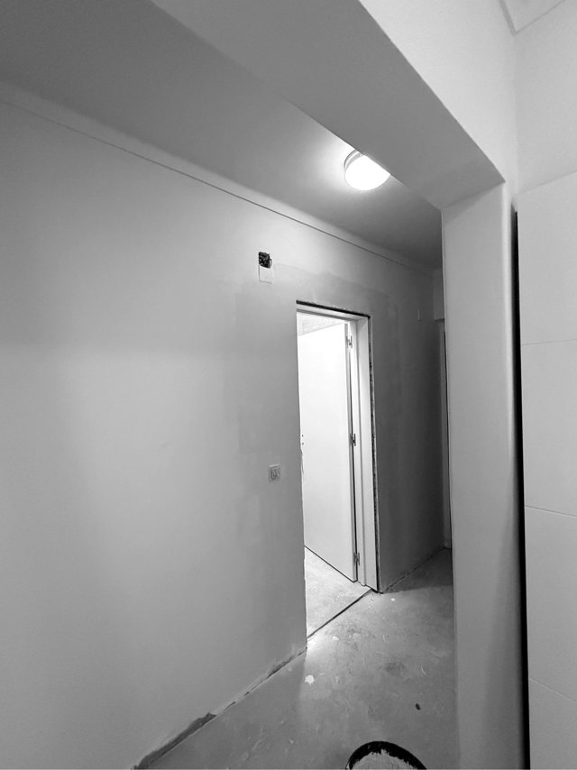 Corredor pintado e iluminado, com remates e pavimento por concluir, Lavradio — fotografia 1 de 2