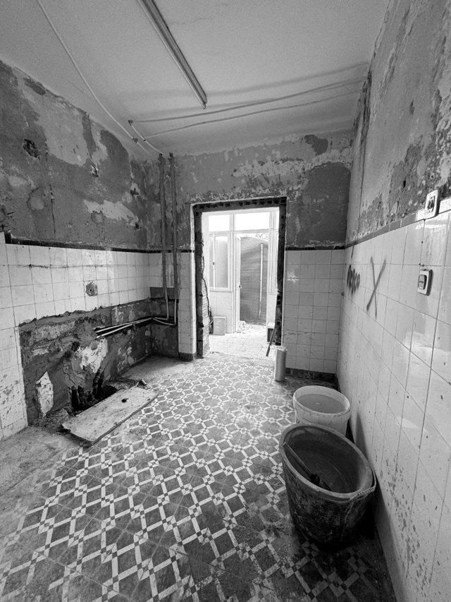 Cozinha em demolição, com azulejos antigos e tubagens à vista, Lavradio