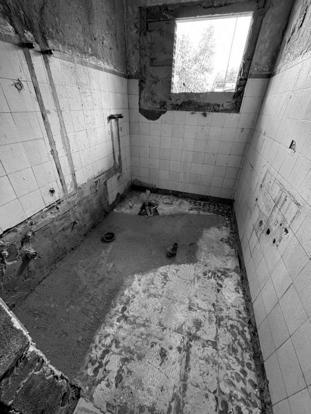 Instalação sanitária em demolição com canalizações expostas e novo vão de janela, Lavradio — fotografia 6 de 7